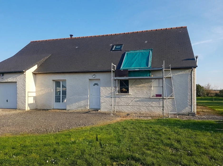 Maison individuelle de plain-pied avec combles aménagés, façade enduit blanc, toiture en ardoise avec fenêtres de toit Velux
