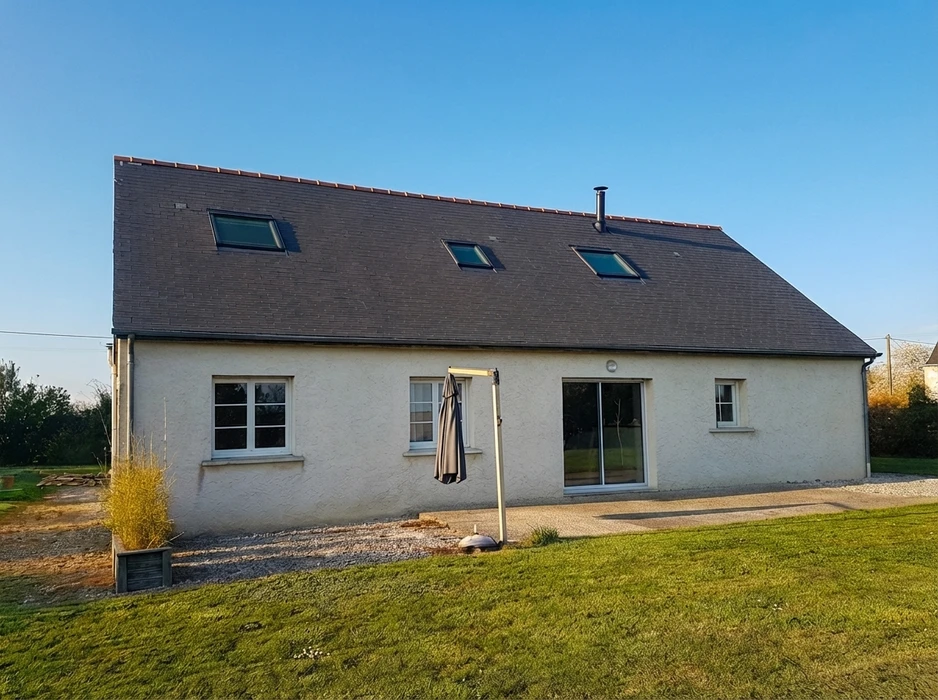 Maison individuelle plain-pied avec combles aménagés, façade enduit blanc, toiture en ardoise naturelle à forte pente avec 3 fenêtres de toit type Velux