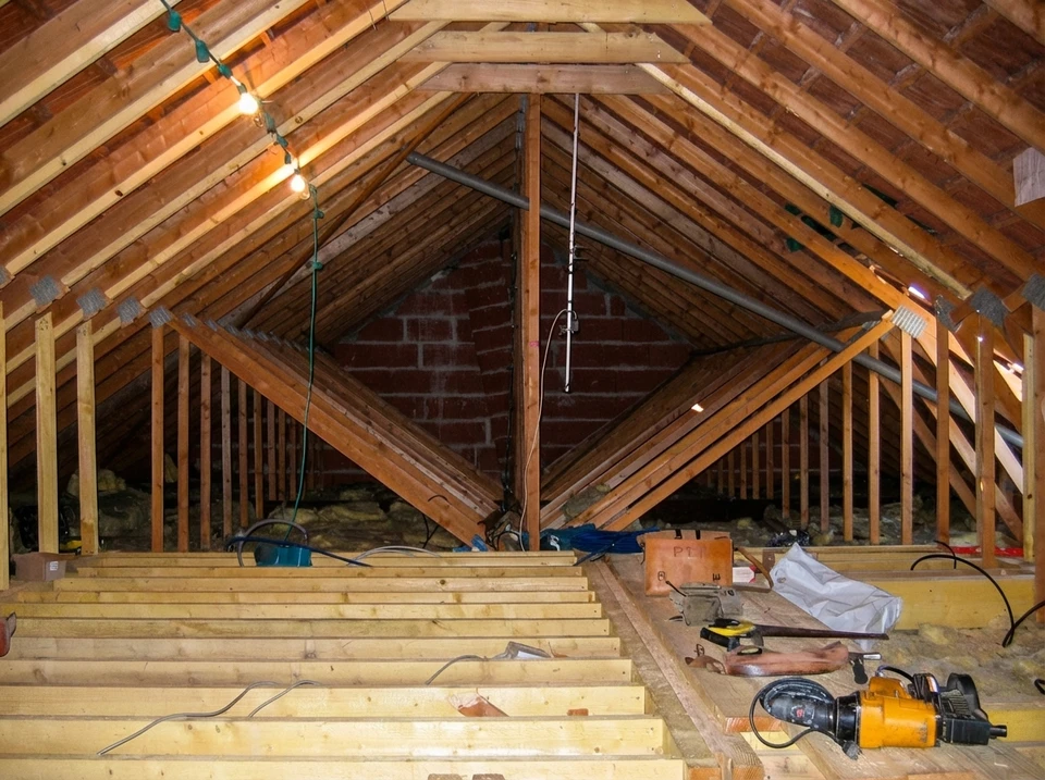 Artisan en équipements de protection individuelle applique du mastic silicone le long d'une baie vitrée dans un bâtiment en construction