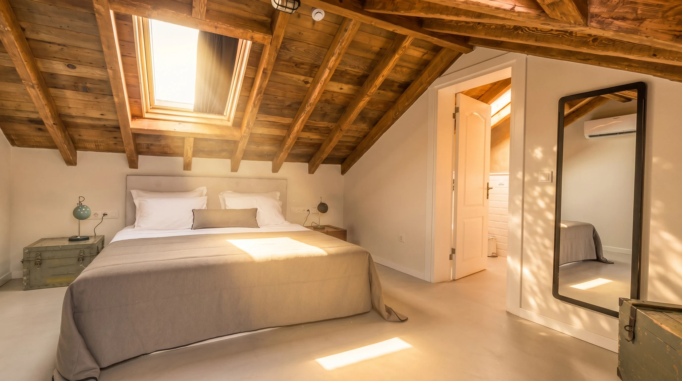 Photographie réaliste en couleur montrant un artisan en train d'installer une isolation en chanvre biosourcé à l'intérieur d'une maison en rénovation. L'artisan, vêtu de vêtements de travail professionnels, place ou pose les panneaux d'isolation naturelle sur une structure charpentée. La scène doit montrer clairement les matériaux naturels (couleur beige clair caractéristique du chanvre) dans un contexte d'aménagement de combles ou de rénovation intérieure. La lumière naturelle ou professionnelle doit bien éclairer le travail en cours, mettant en évidence la qualité et la précision du travail artisanal.