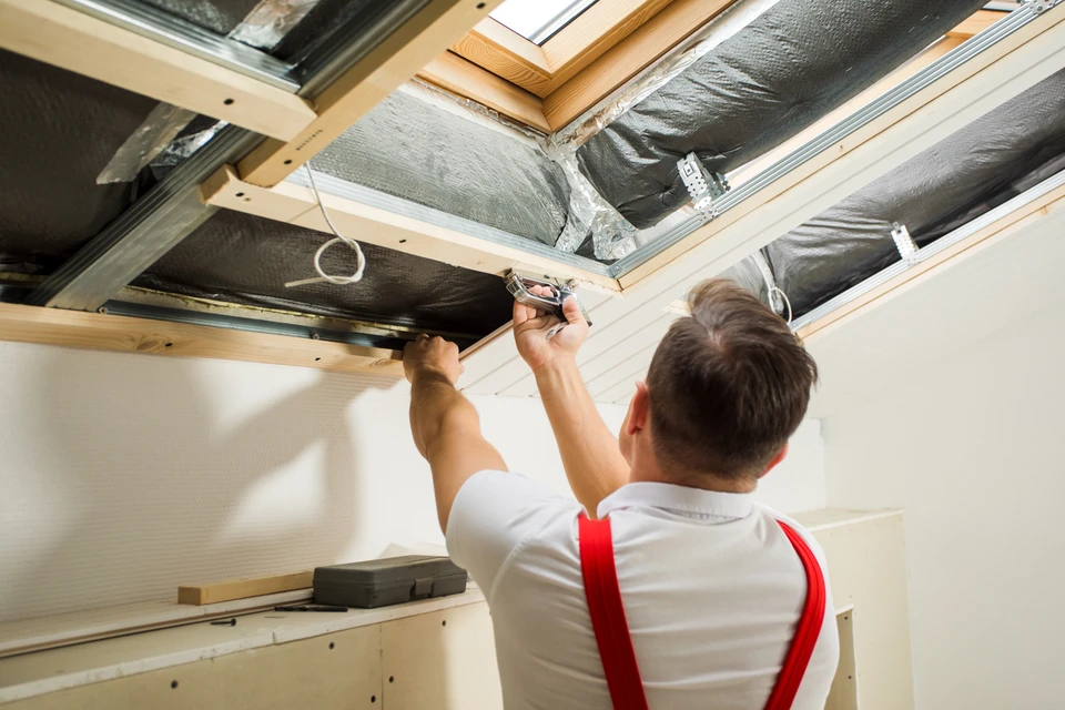 Combles aménageables en cours de rénovation avec charpente bois apparente et isolation sous-toiture